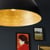 Metal pendant illumating a simple gallery wall
