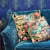 Blue sofa with patterned pillows and peacock wall paper